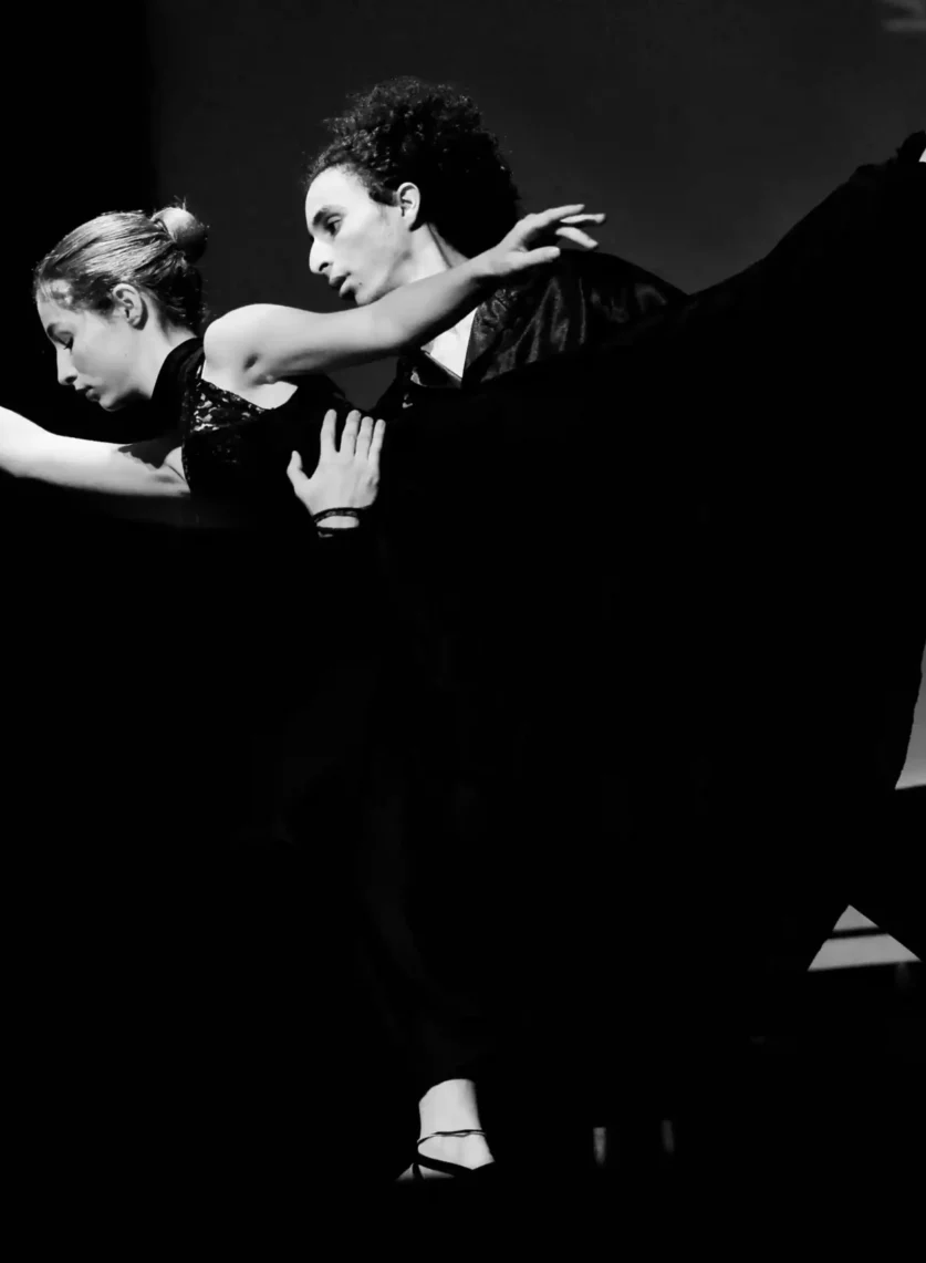 Danse contemporaine en noir et blanc avec deux danseurs exécutant une performance passionnée."