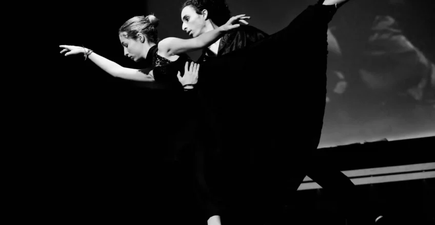 Danse contemporaine en noir et blanc avec deux danseurs exécutant une performance passionnée."