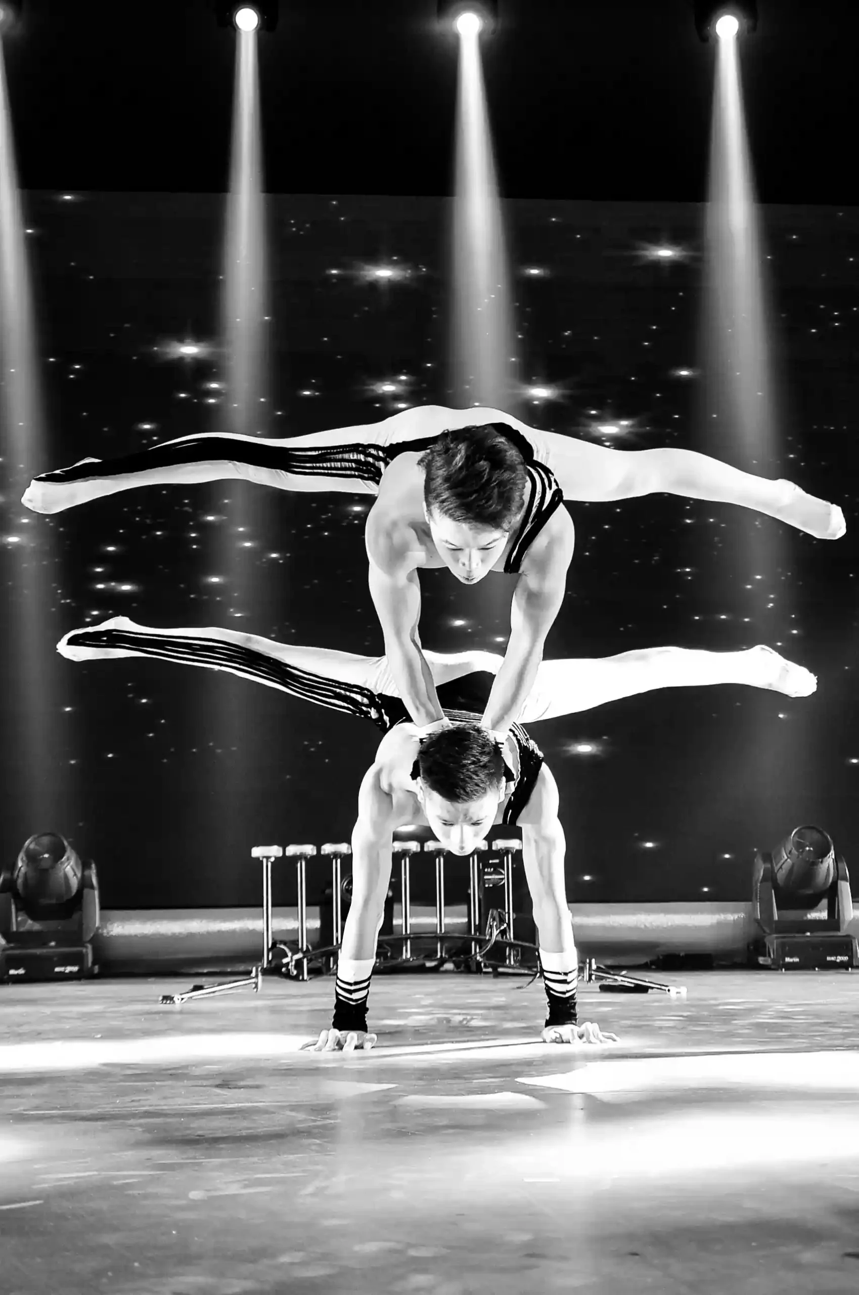 ⁠Photographie acrobate en action : un artiste réalisant une figure spectaculaire lors d'une performance sur scène.